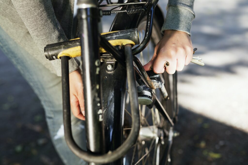 Cropped hand of woman locking bicycle